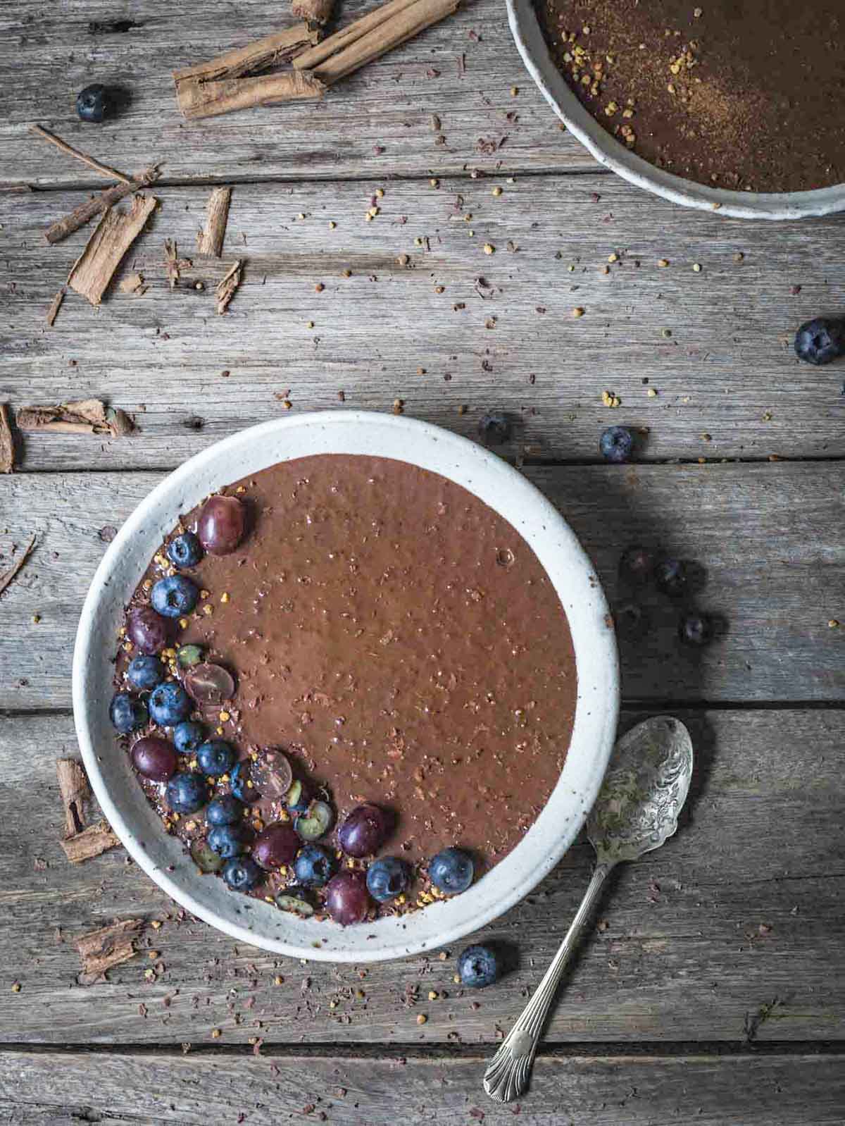 Two bowls of chia pudding on a rustic table setting. 