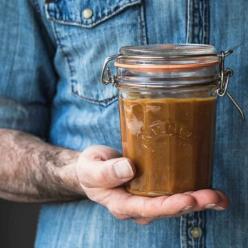A man holding a jar of caramel.