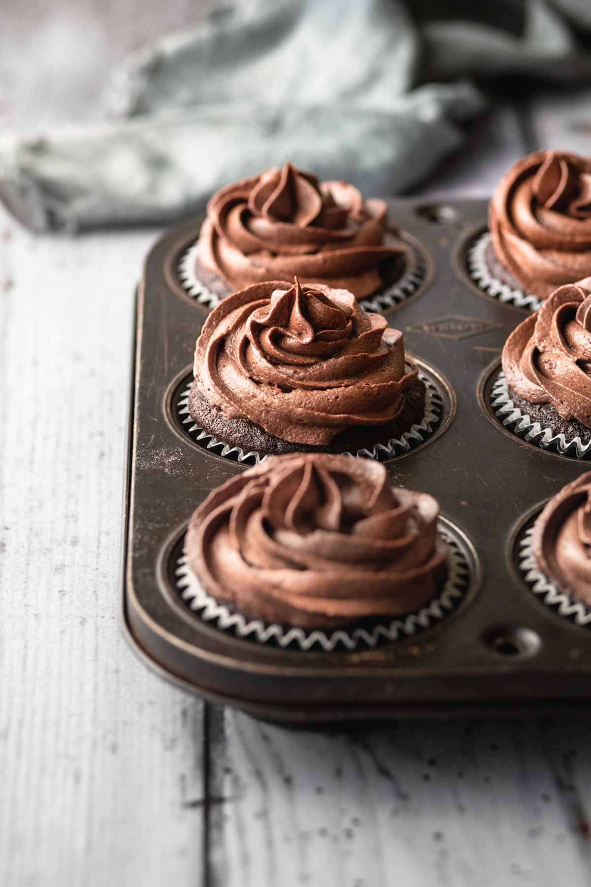 A tray of frosted chocolate cupcakes in a vintage baking pan.