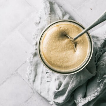 A jar of freshly made cashew butter on a napkin.