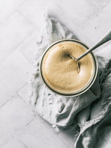 A jar of freshly made cashew butter on a napkin.