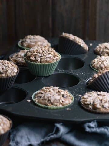 Freshly baked zucchini chocolate chip muffins with toasted oat topping.