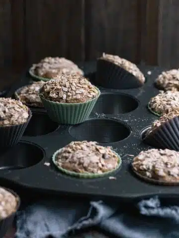 Freshly baked zucchini chocolate chip muffins with toasted oat topping.