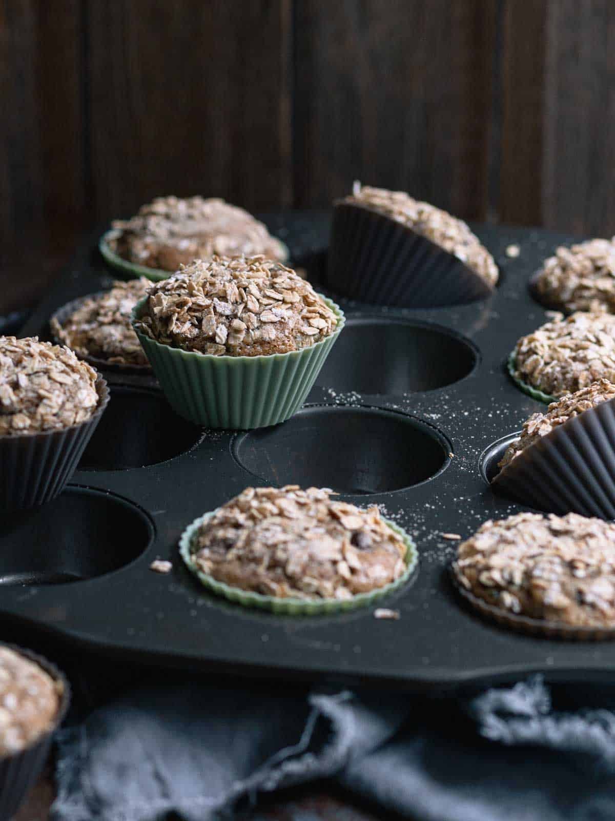 Freshly baked zucchini chocolate chip muffins with toasted oat topping.