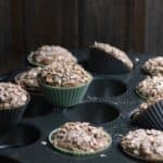 Freshly baked zucchini muffins with crunchy oat topping on a tray.