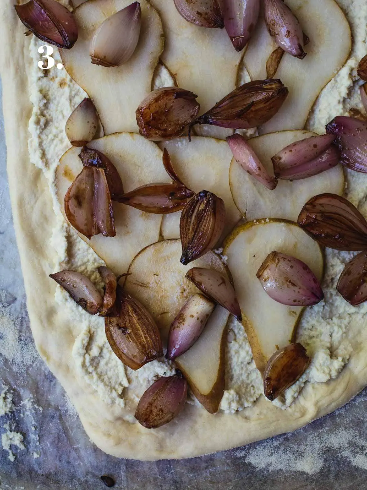 White pizza with pears and shallots before the oven.