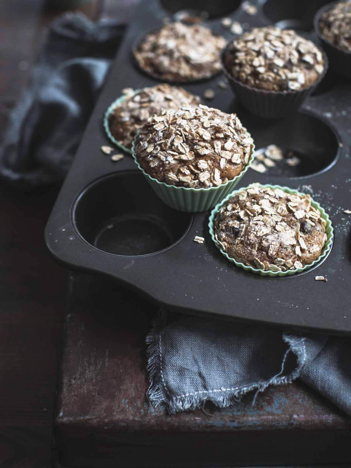 Baked muffins with oatmeal on a baking tray.