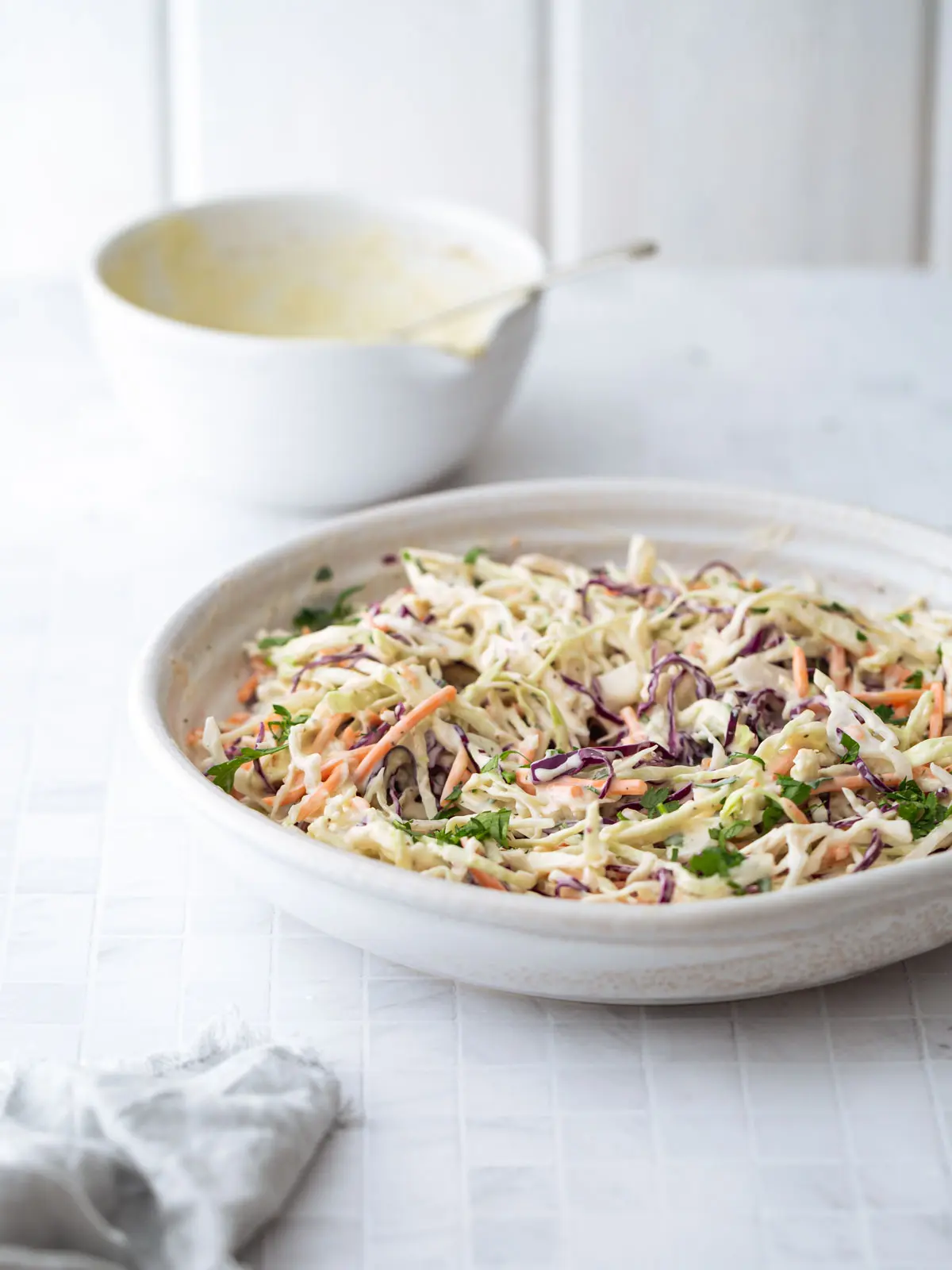 A table setting with a large bowl of shredded salad.