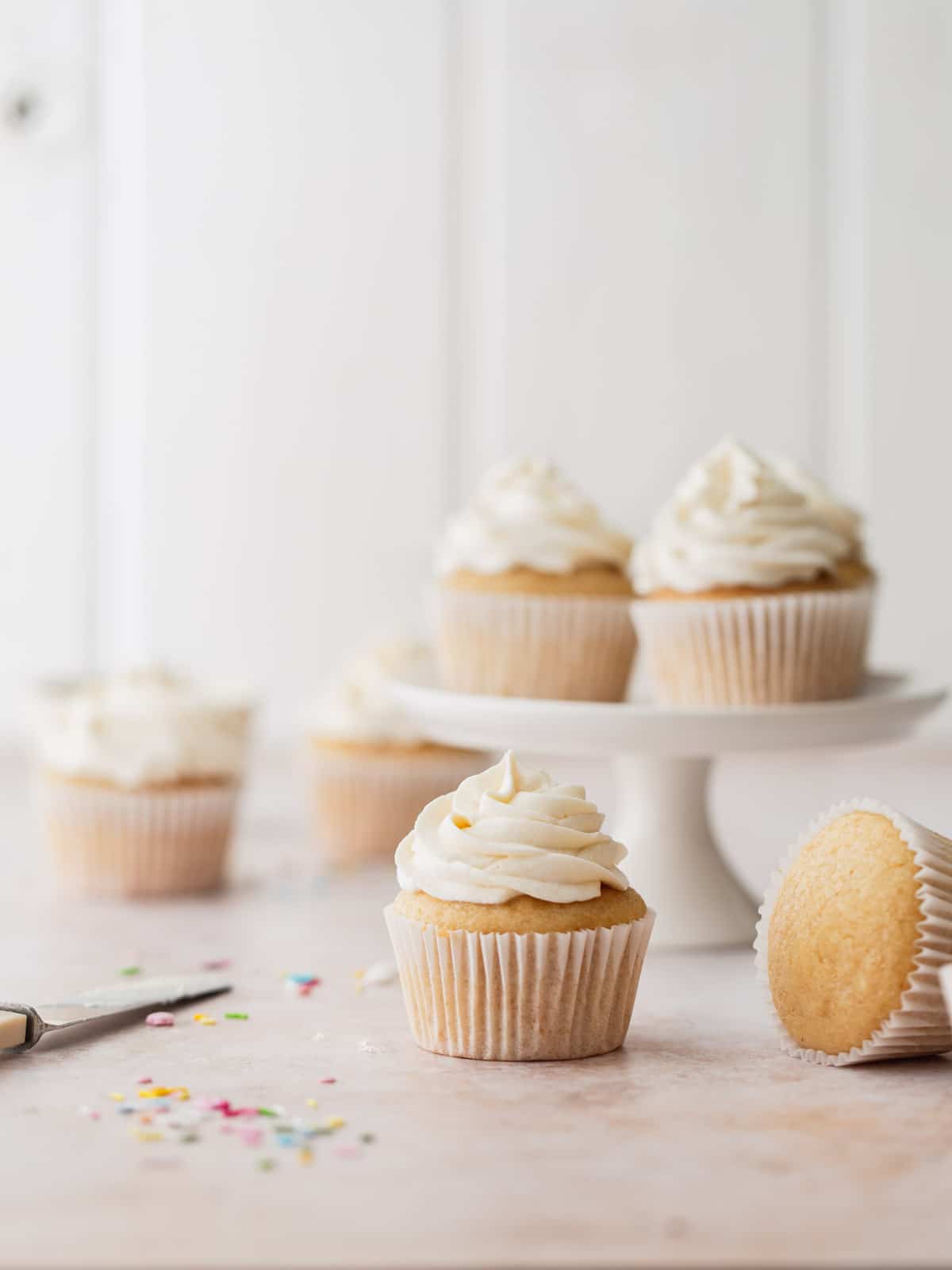 Frosted vanilla cupcakes on a white background.