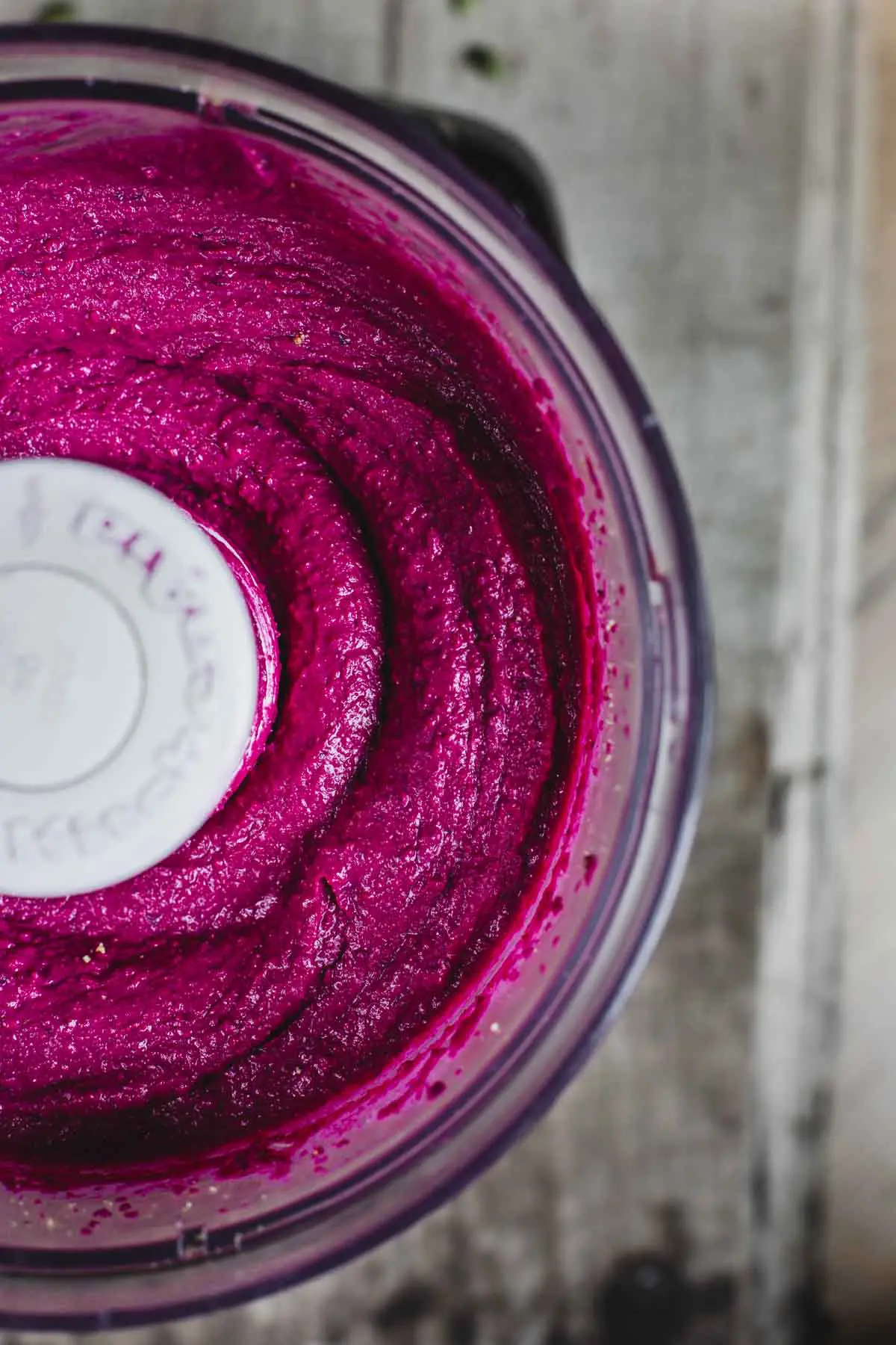 Beetroot hummus being chopped in a food processor.