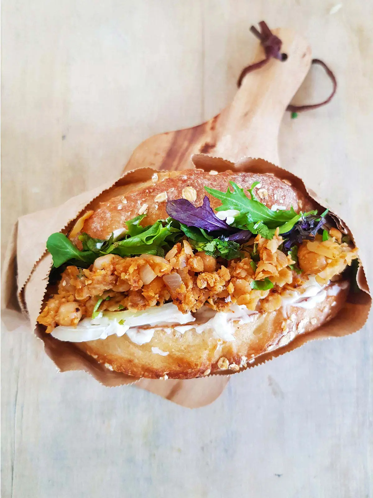 A crispy vegetable burger in a lunch bag.