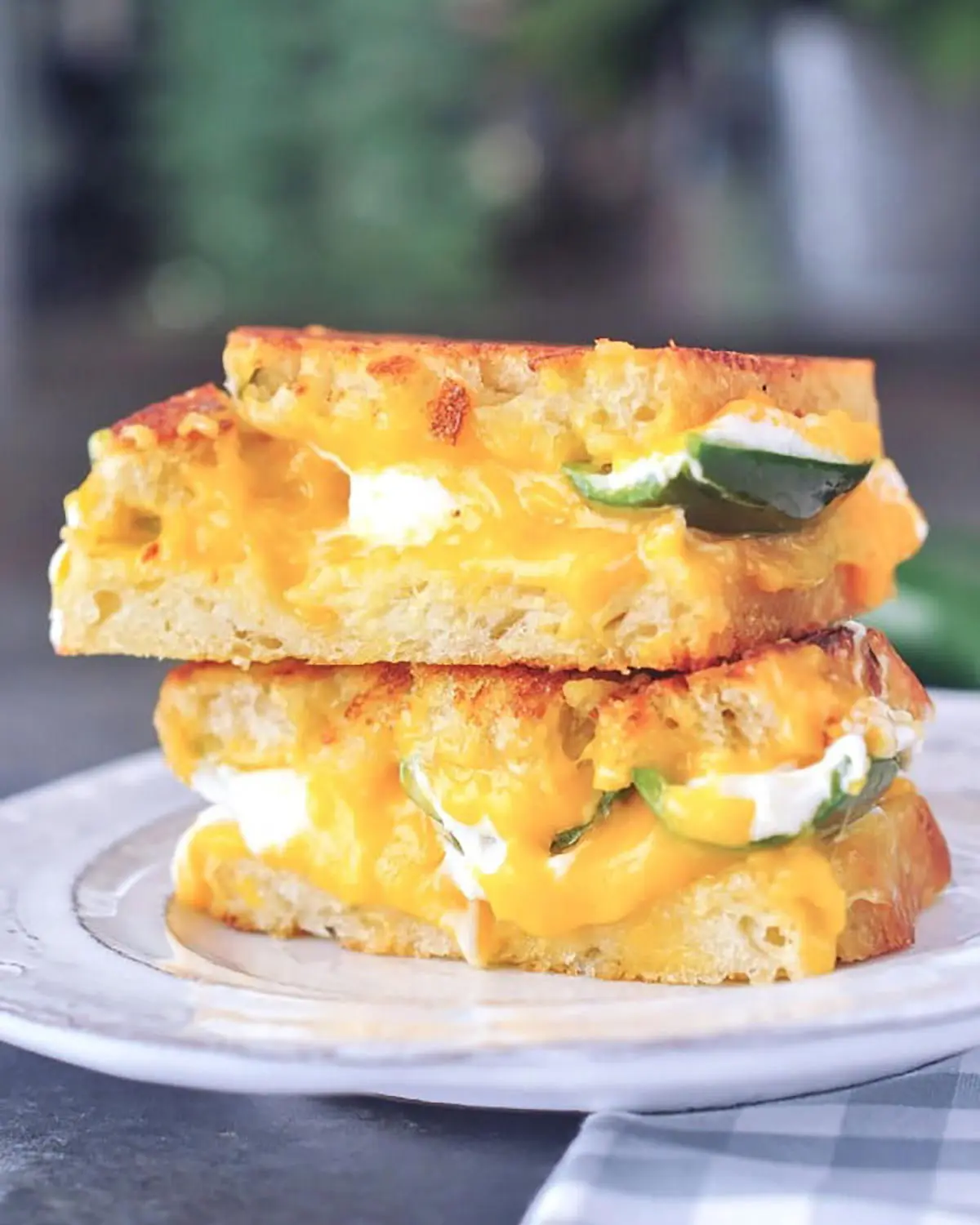 A stacked melted cheese sandwich on a plate.