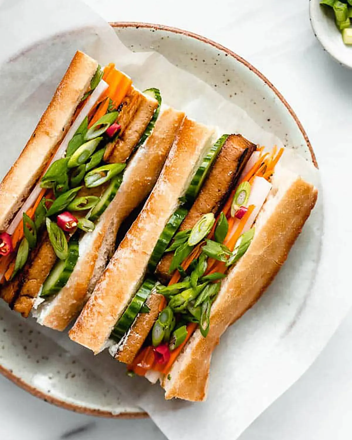 A tofu banh mi on a white plate.