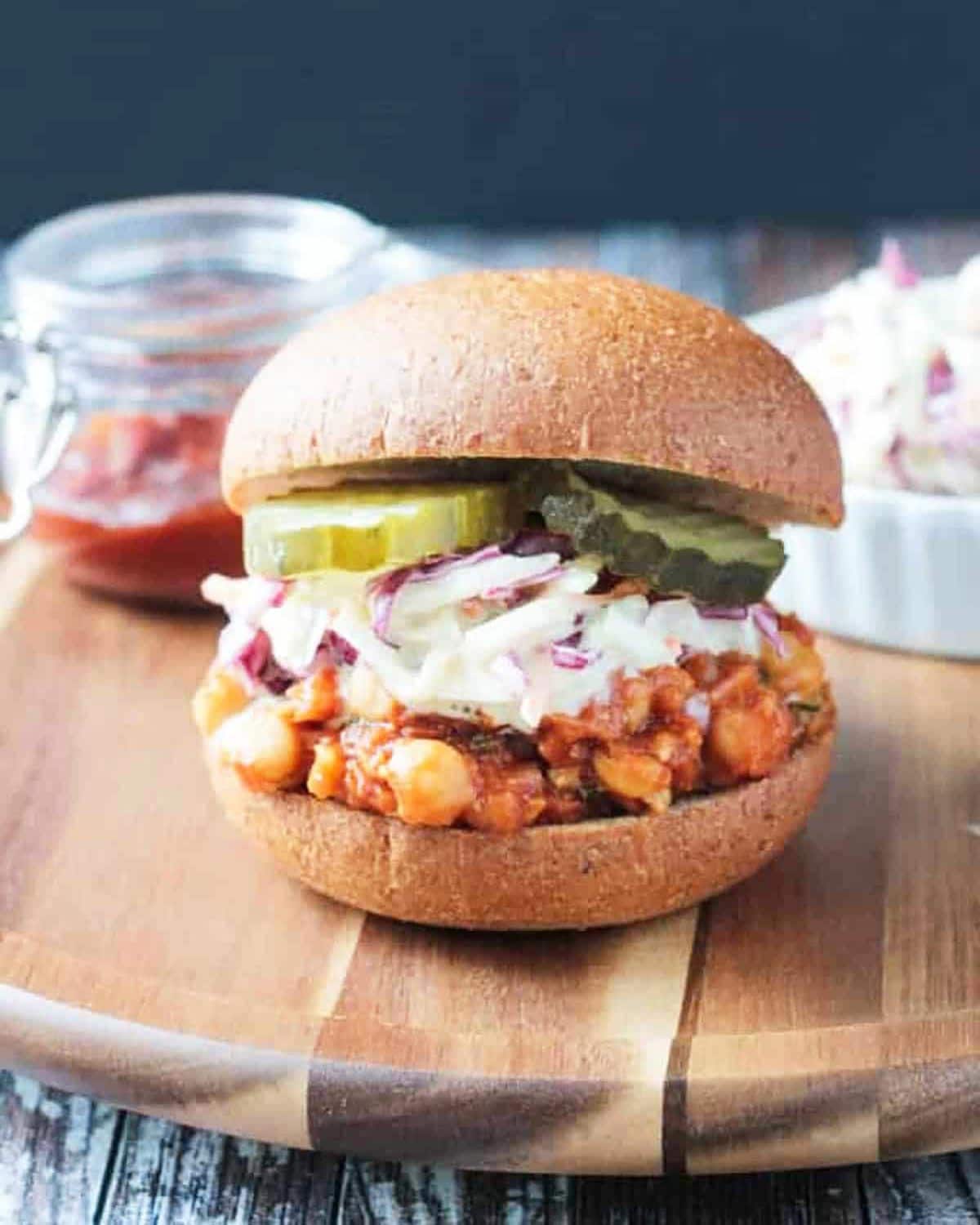 Smashed chickpeas with pickles on a board.