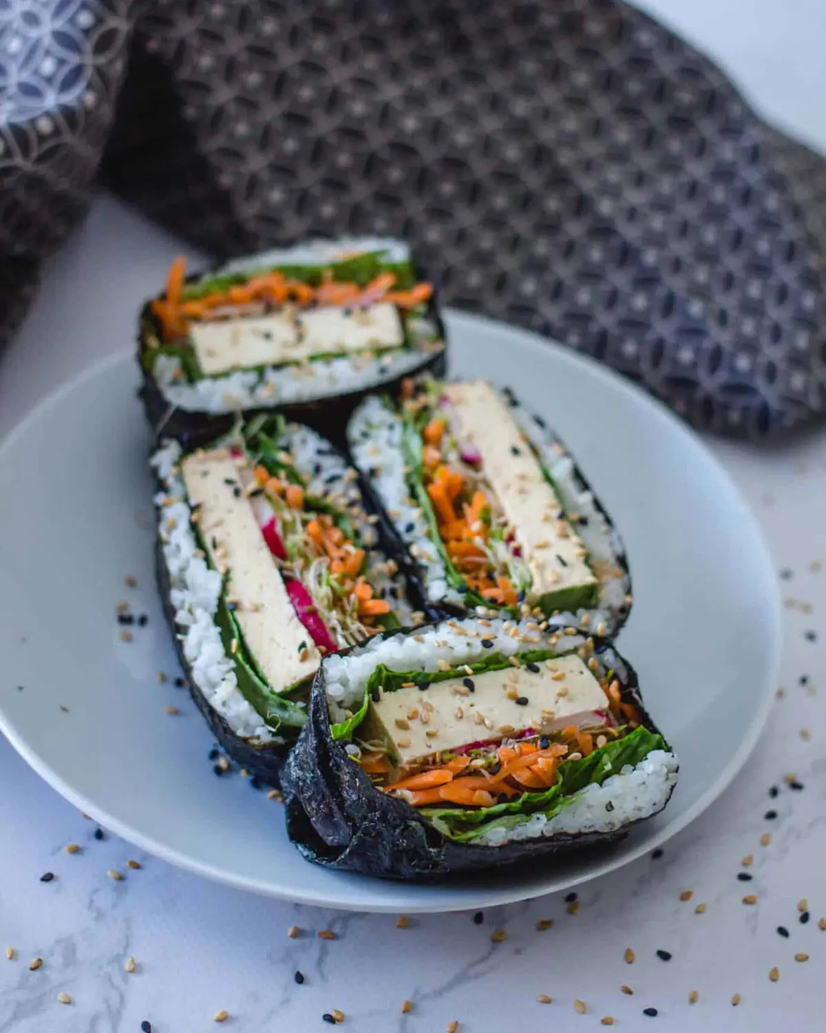 Vegetable and tofu sushi on a plate.