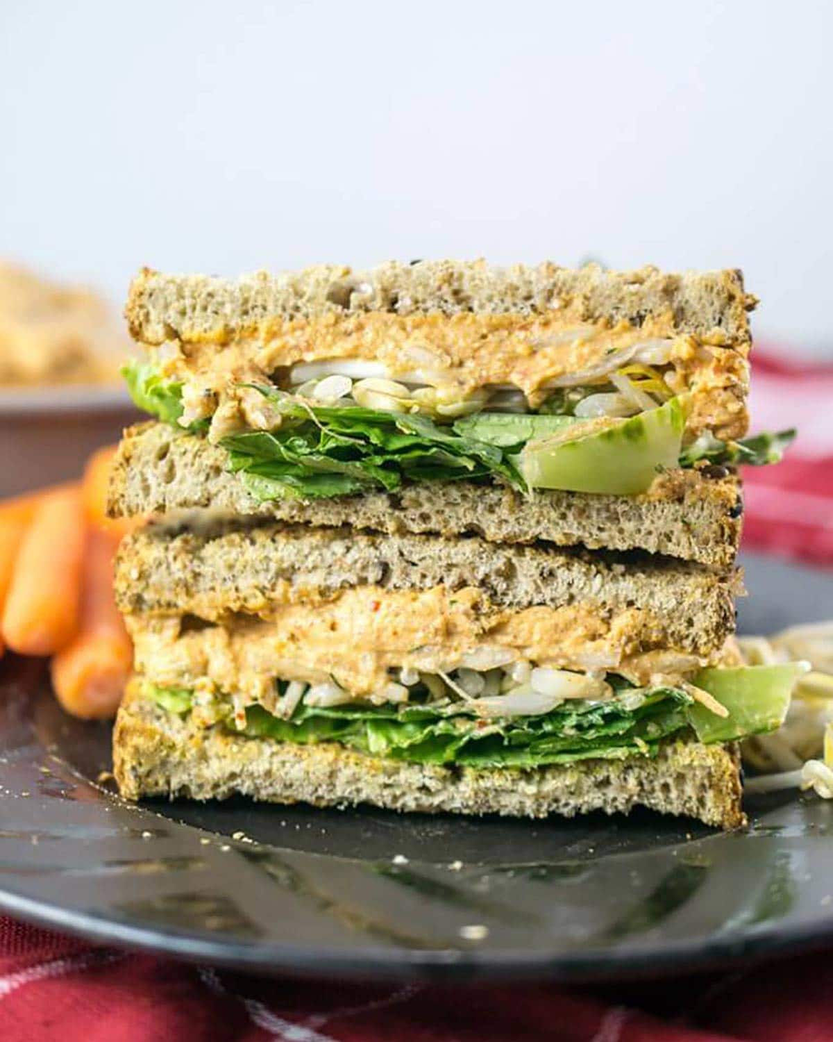 A vegan egg salad sandwich stacked on a plate.