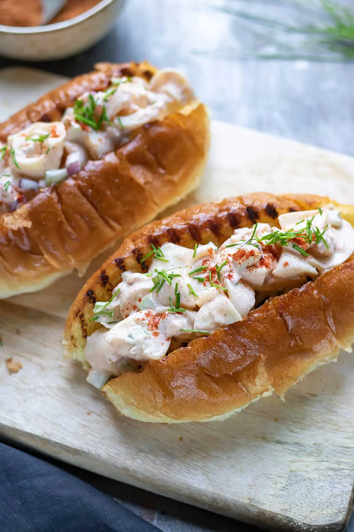 Lobster rolls on a wooden board.