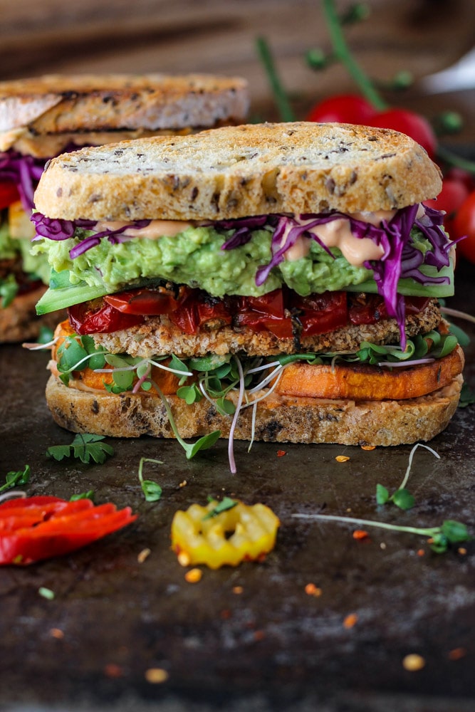 A stacked sandwich with tofu, veggies and avocado.