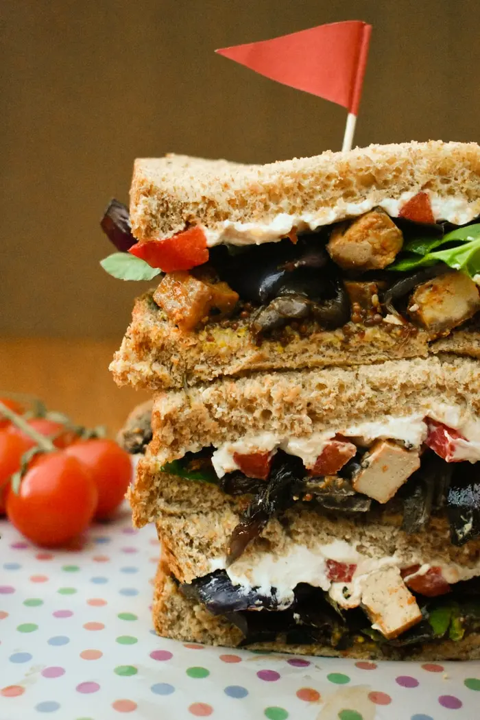 A stacked sandwich with tofu and vegetables. 