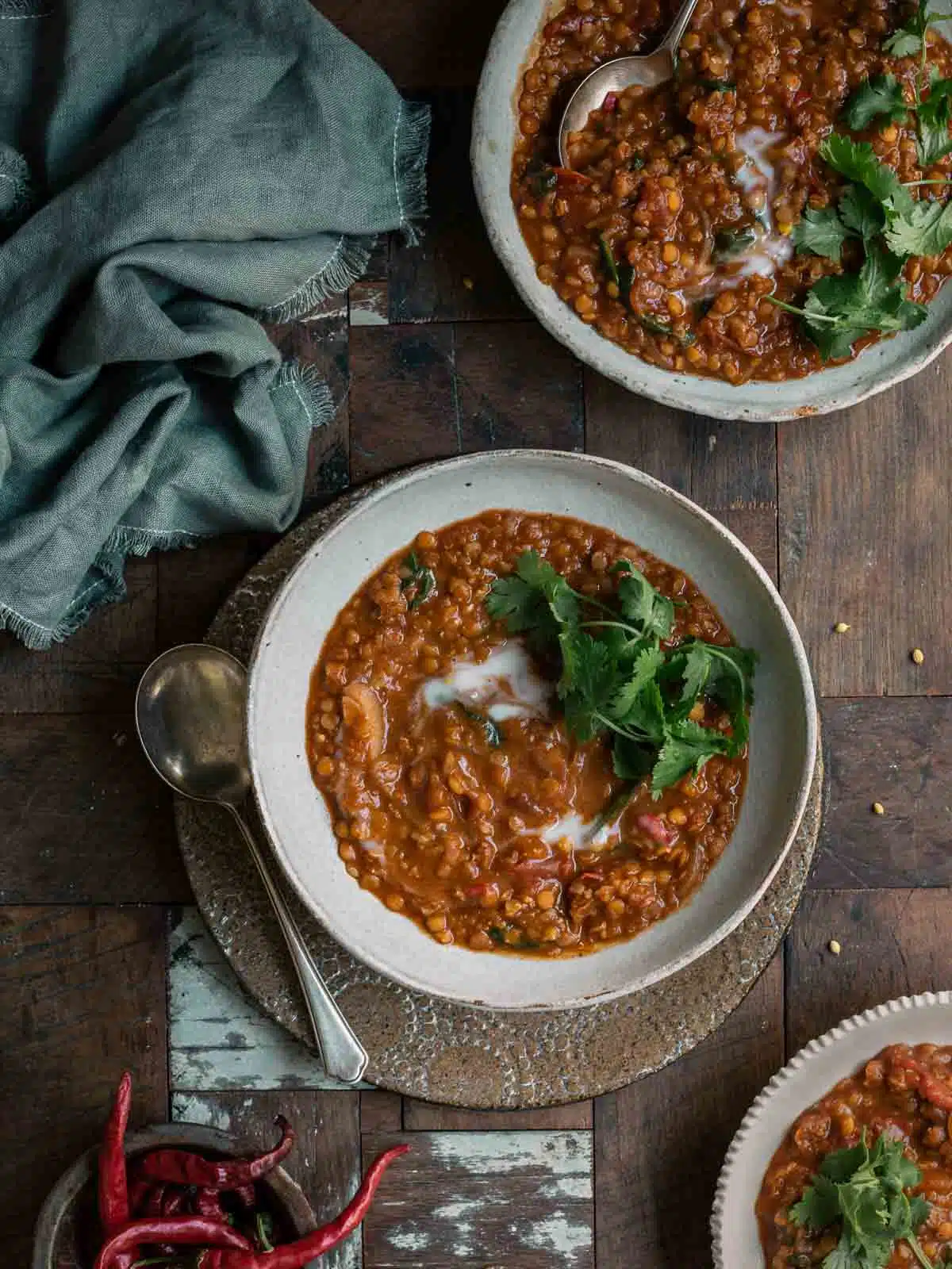 Bowls of lentil curry on a wooden table. 