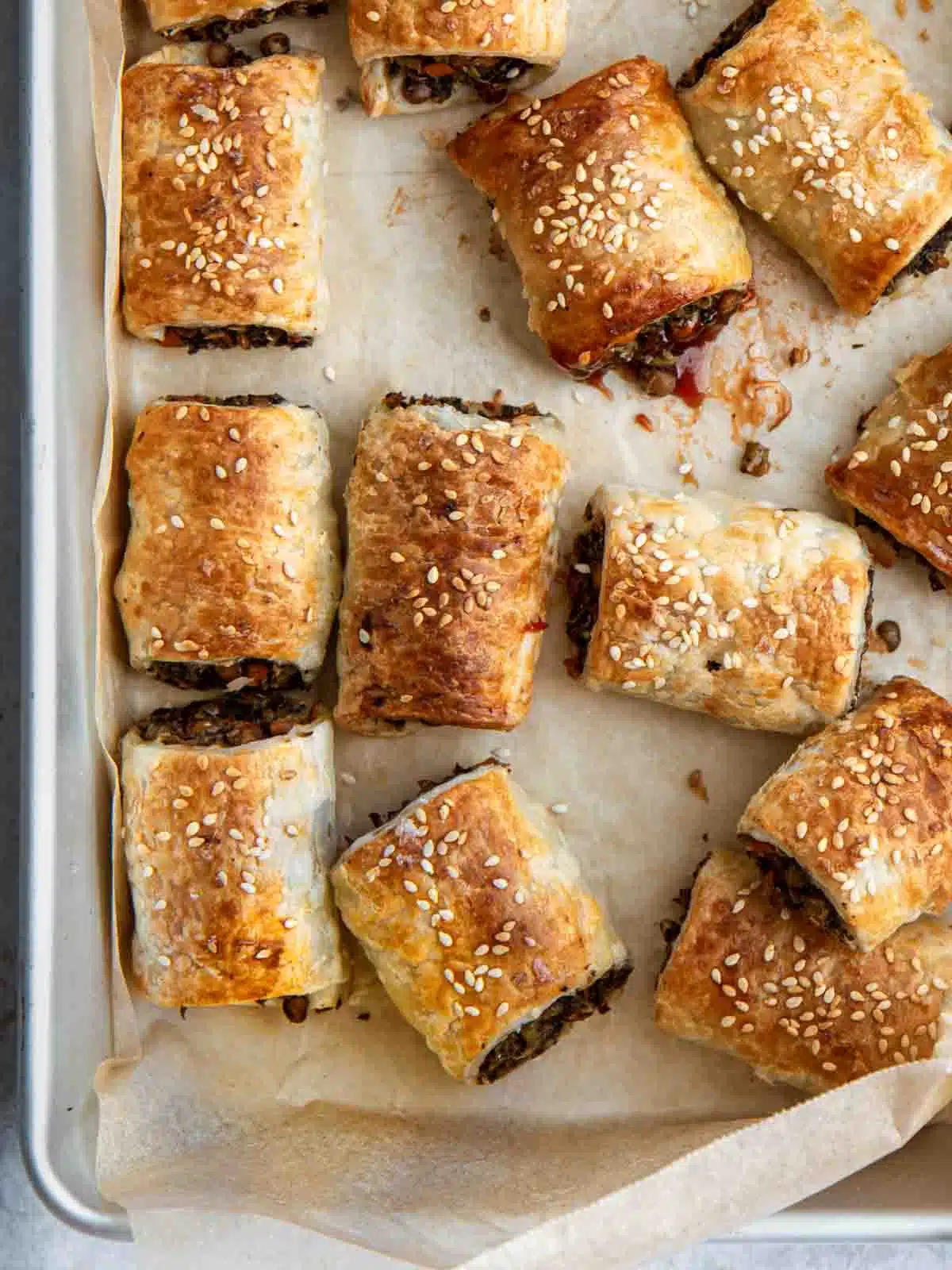 Sausage rolls on a baking tray.