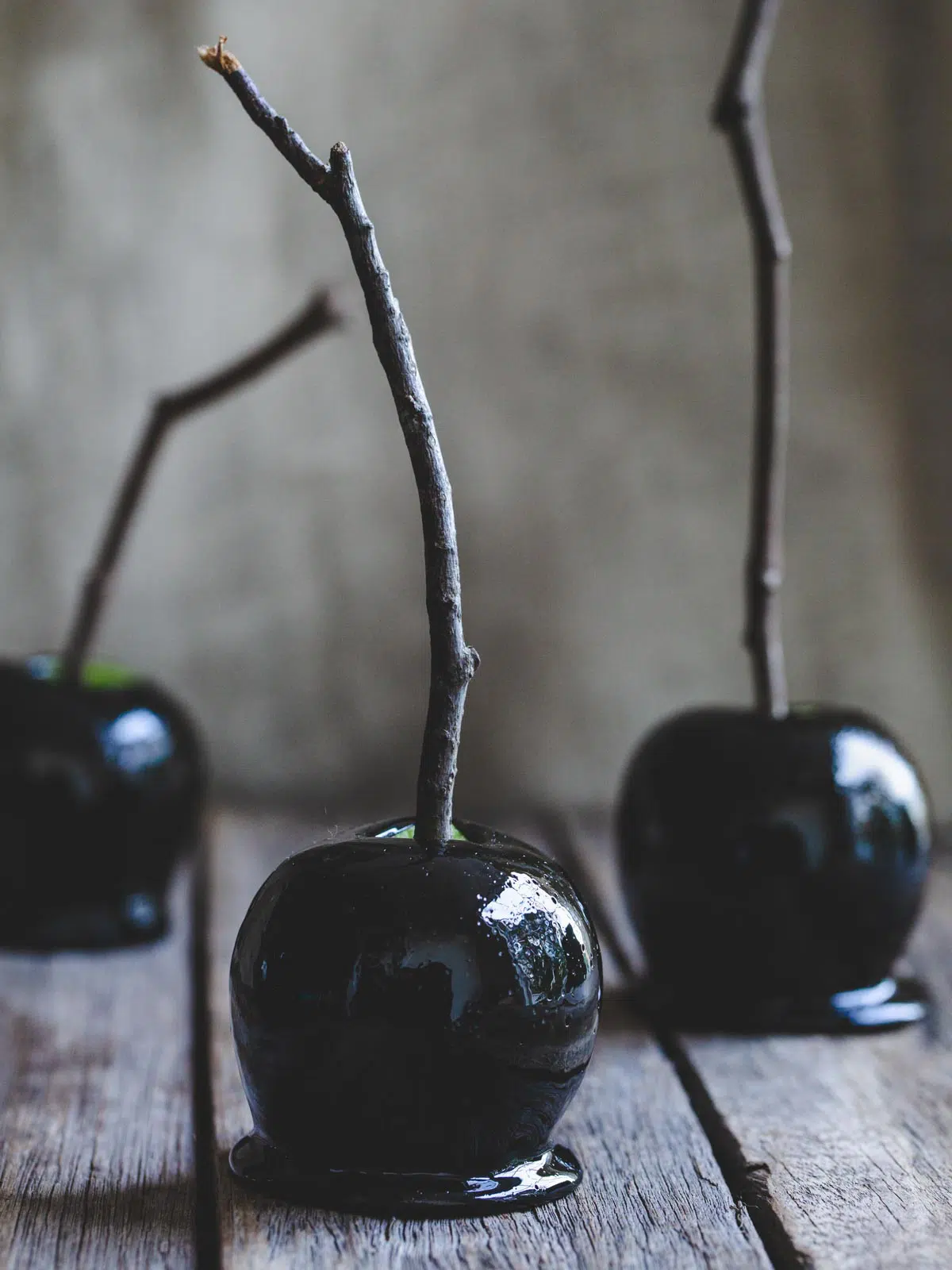 Black candy apples on a wooden table.  