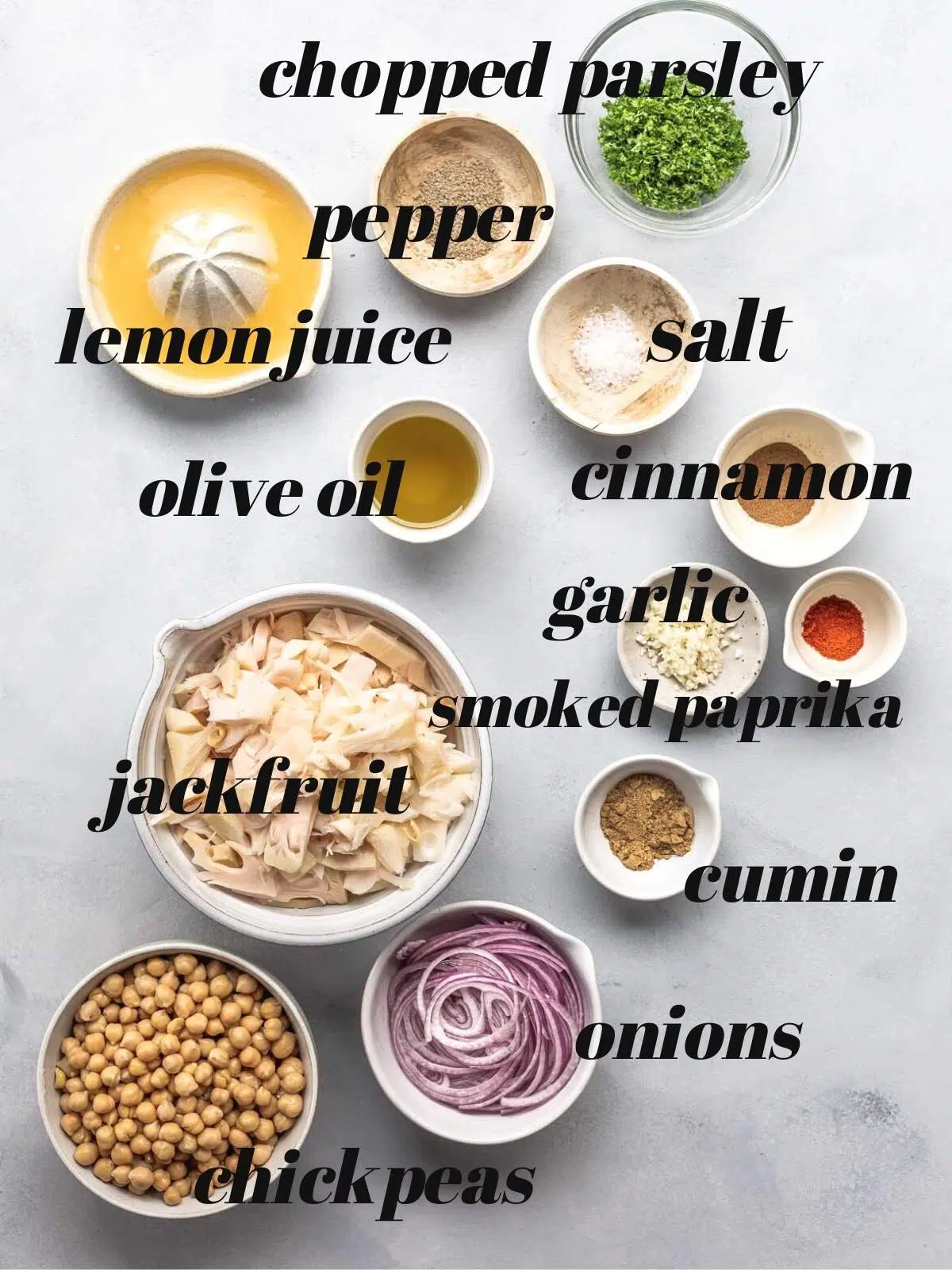 Labelled ingredients in bowls on a grey surface.