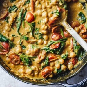 Close up of chickpea curry with tomatoes and spinach.