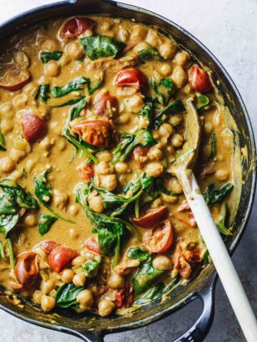 A large skillet of chickpea, spinach and tomato curry.