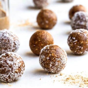 Coated and uncoated bliss balls on a white surface.
