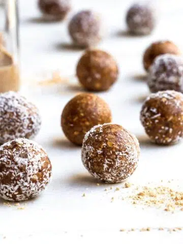 Coated and uncoated bliss balls on a white surface.