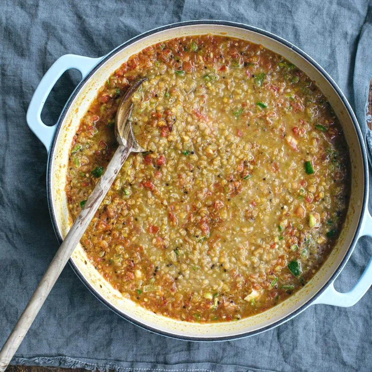 Cooked lentils with tomatoes in a pan.