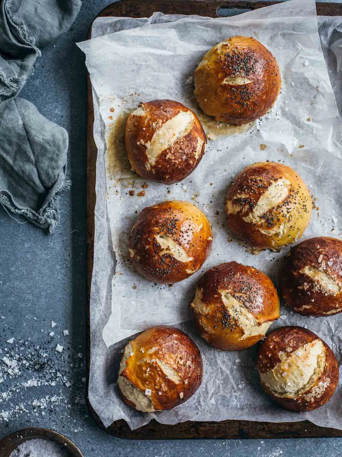 Pretzel buns fresh from the oven on a tray.