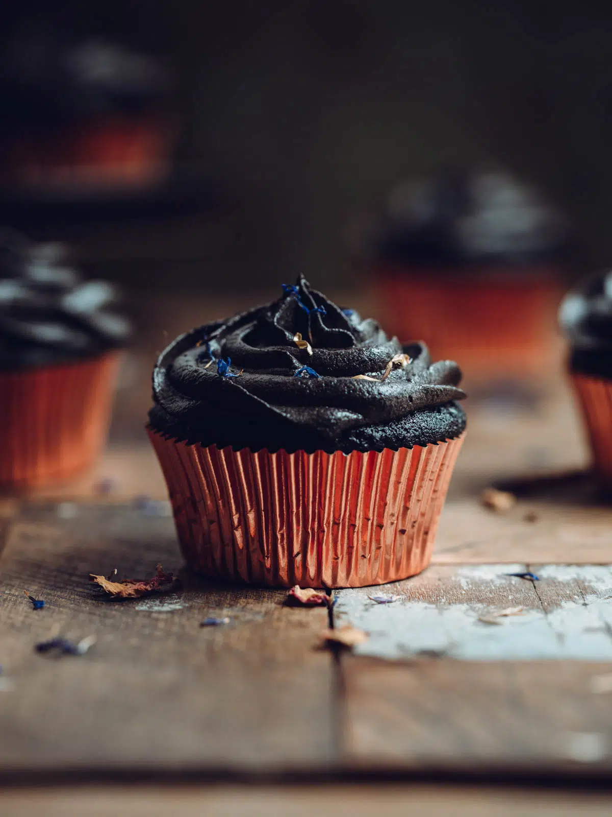 Black velvet cupcakes on a wooden table.
