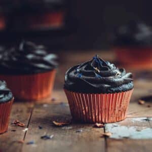 Black cupcakes with black frosting and sprinkles.