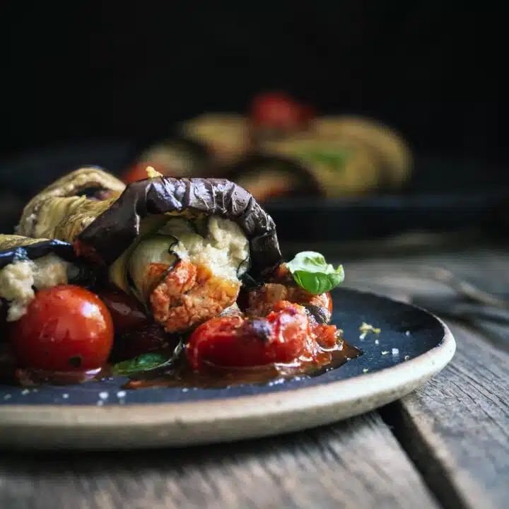 A stuffed eggplant roll on a plate.