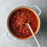 A large pot of freshly cooked tomato service with herbs.