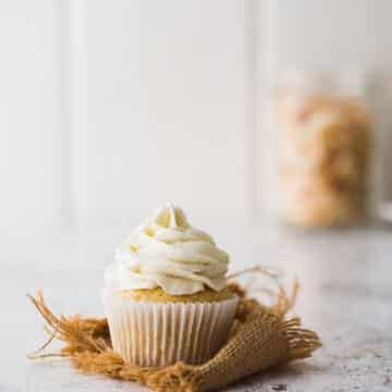A pineapple cupcake with coconut frosting.