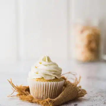A pineapple cupcake with coconut frosting.