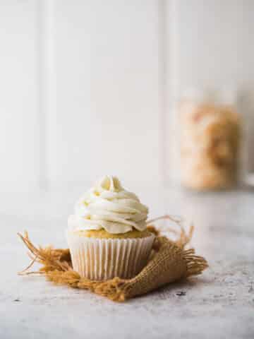 A pineapple cupcake with coconut frosting.