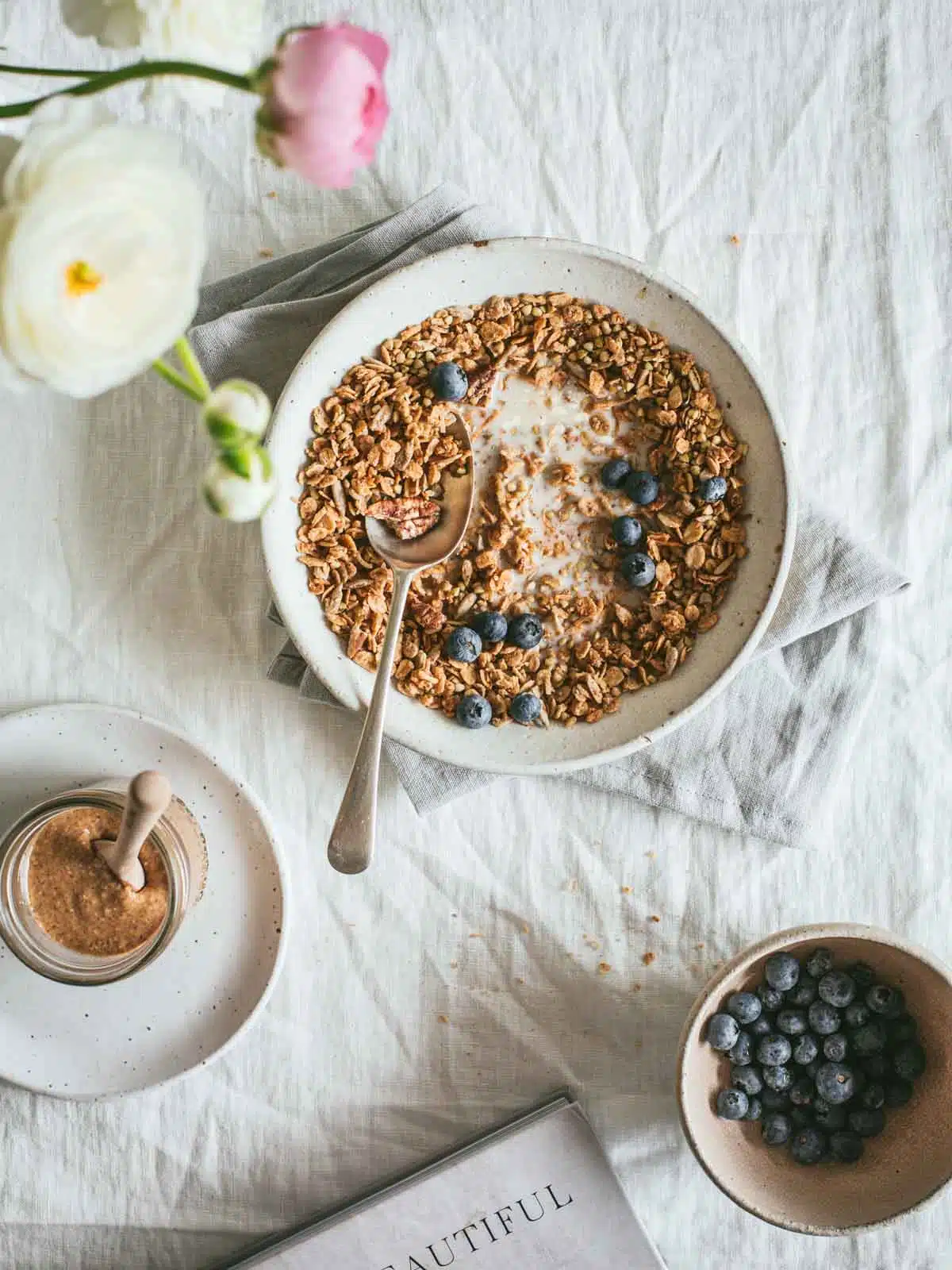 A breakfast setting with a bowl of granola. 