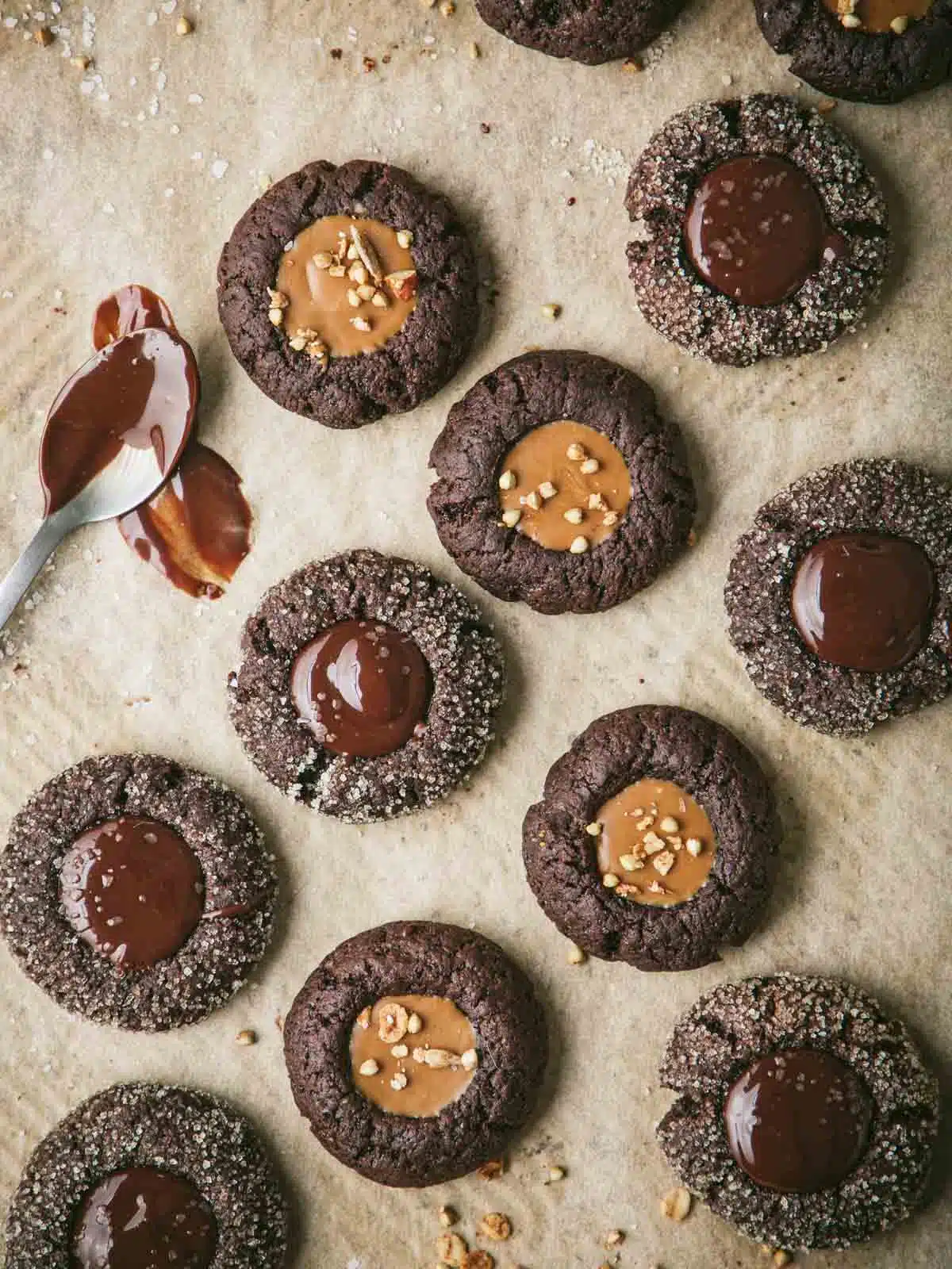 A tray of thumbprint cookies with melted chocolate.