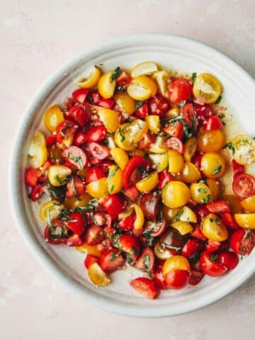 A white plate with tomatoes.