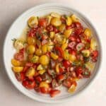 Tomato and onion salad on a white plate.