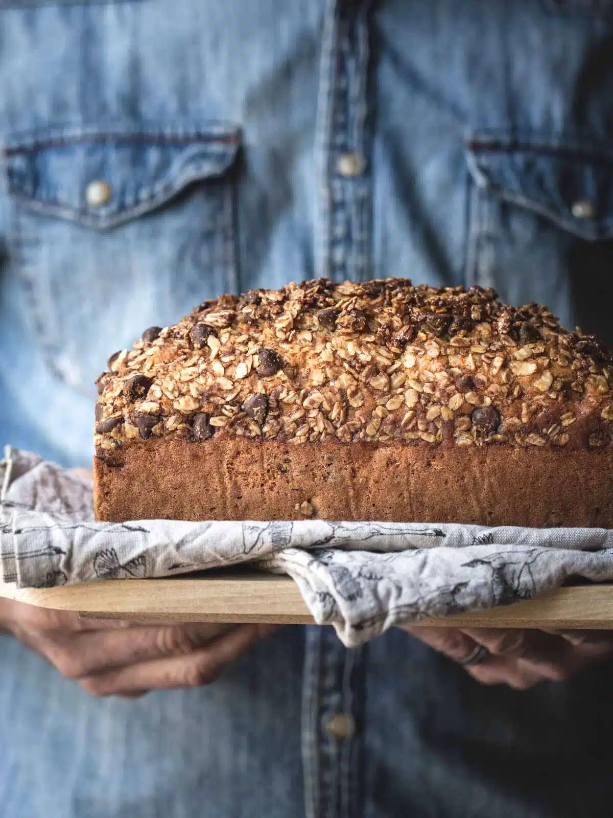 A man holding a loaf of banana bread.