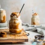 Three milkshakes with cream on a table.