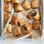 A tray of baked sausage rolls on a tray.