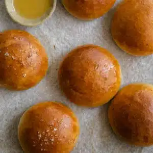 Brioche buns on a baking tray.