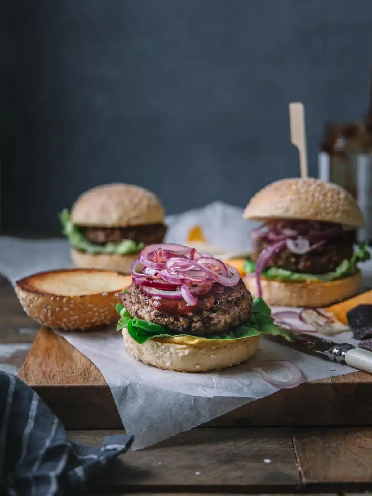 A burger with the bun lid removed.