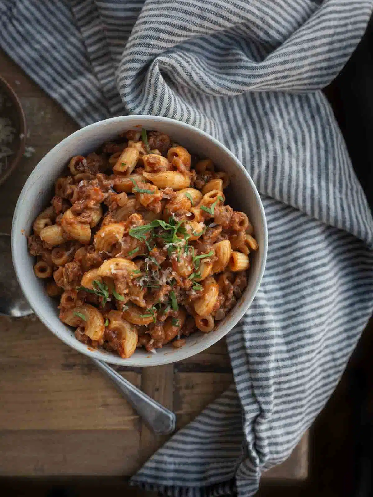 A bowl of pasta and a napkin on a table.